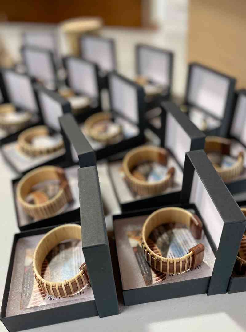 three rows od boxes with wooden cuff bracelet for men or women in open boxes