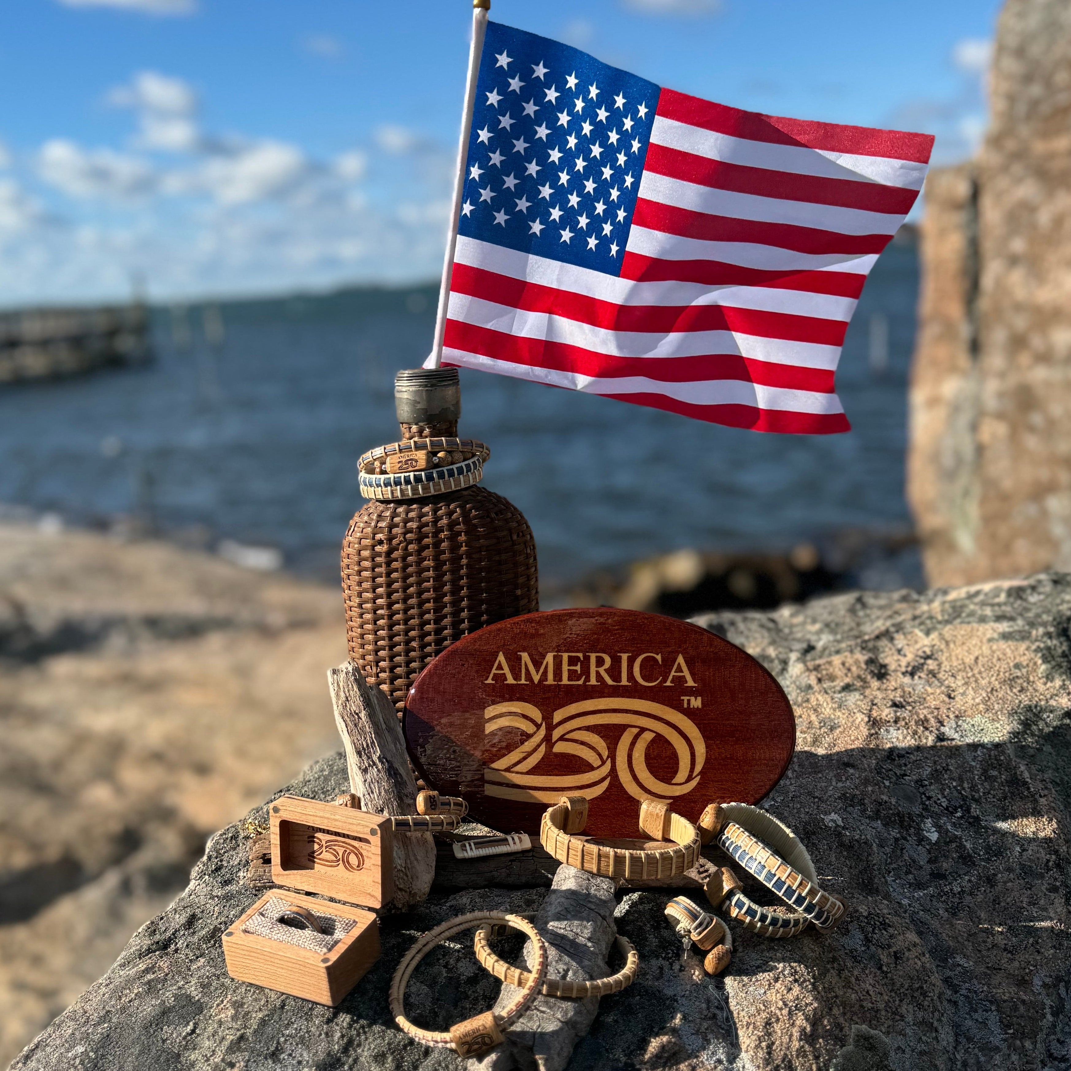 collection of jewelry and hitch cover on a rock ith woden jar and American flag behind them