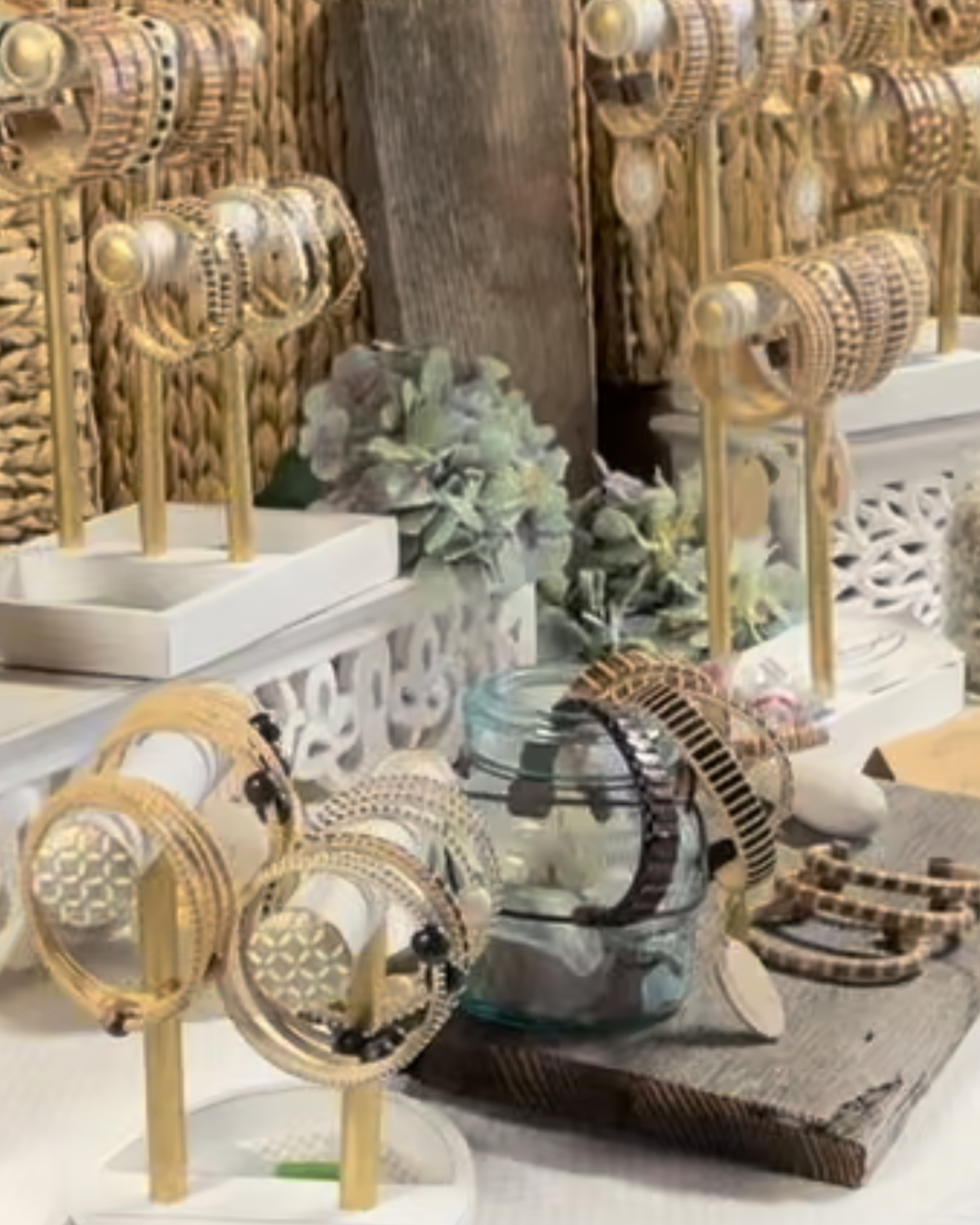 bracelets on white stands and cuff bracelets on a glass jar in a retail store