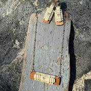 Wooden necklace with heart designs on a textured surface