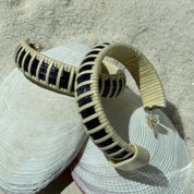 Navy hand-dyed bamboo cane Seasons large hoop earrings with light weaver detailing, a bold coiled design that coordinates with the Seasons bracelet collection — American-made by Military Spouse artisans in Stonington, Connecticut.