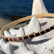 Handcrafted Memories eggplant hand-dyed bamboo cane Secrets bangle bracelet displayed on a starfish by the water — handmade by Military Spouse artisans in Stonington, Connecticut using American-made materials.