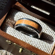 Close-up of a Beacon 8mm tungsten ring with cherry wood inlay resting in an open Drift by Stonington Designs wooden gift box.