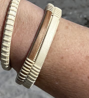 Handcrafted open weave cuff bracelet pairing light holly wood with a walnut center panel, worn on a wrist.
