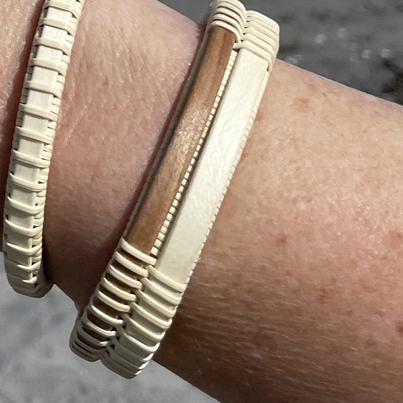 Handcrafted open weave cuff bracelet pairing light holly wood with a walnut center panel, worn on a wrist.