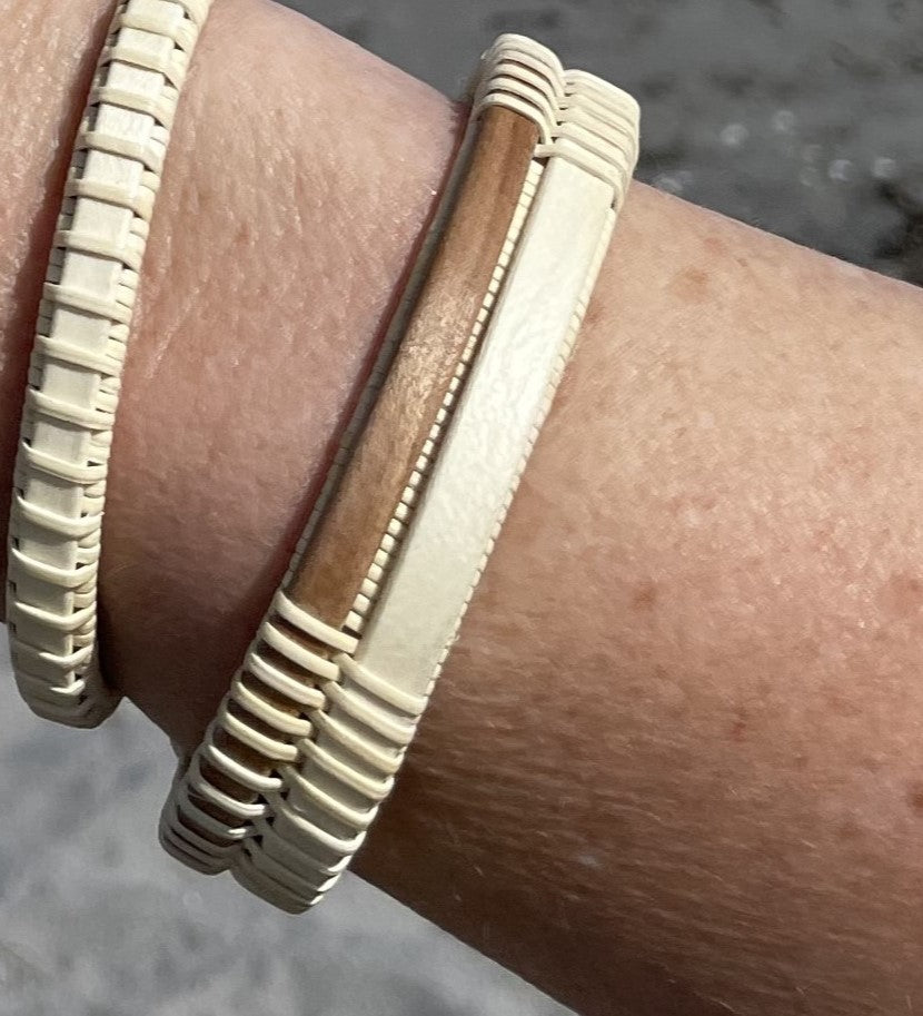 Handcrafted open weave cuff bracelet pairing light holly wood with a walnut center panel, worn on a wrist.