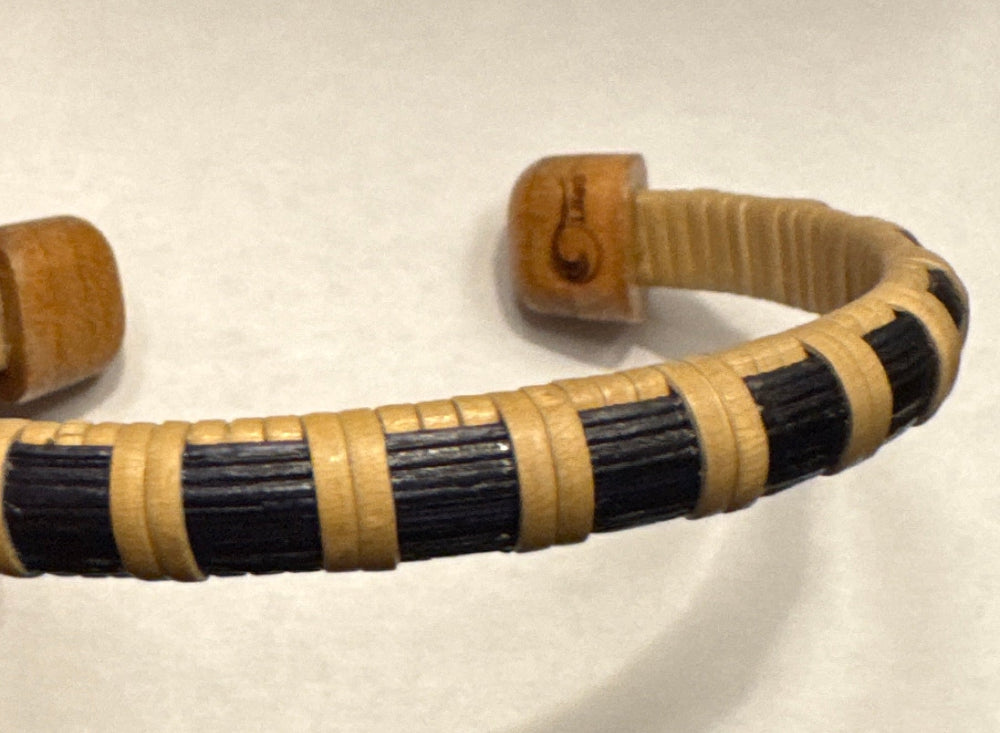 Close-up of the In the Stars cuff bracelet showing the hand-dyed navy wood stave with holly weaving detail and a cherry end cap with engraved etching