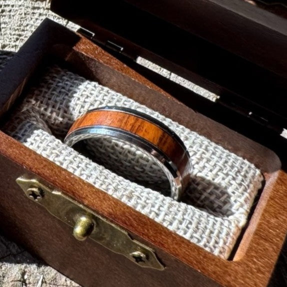 Close-up of a Beacon 8mm tungsten ring with rosewood inlay resting in an open Drift by Stonington Designs wooden gift box.