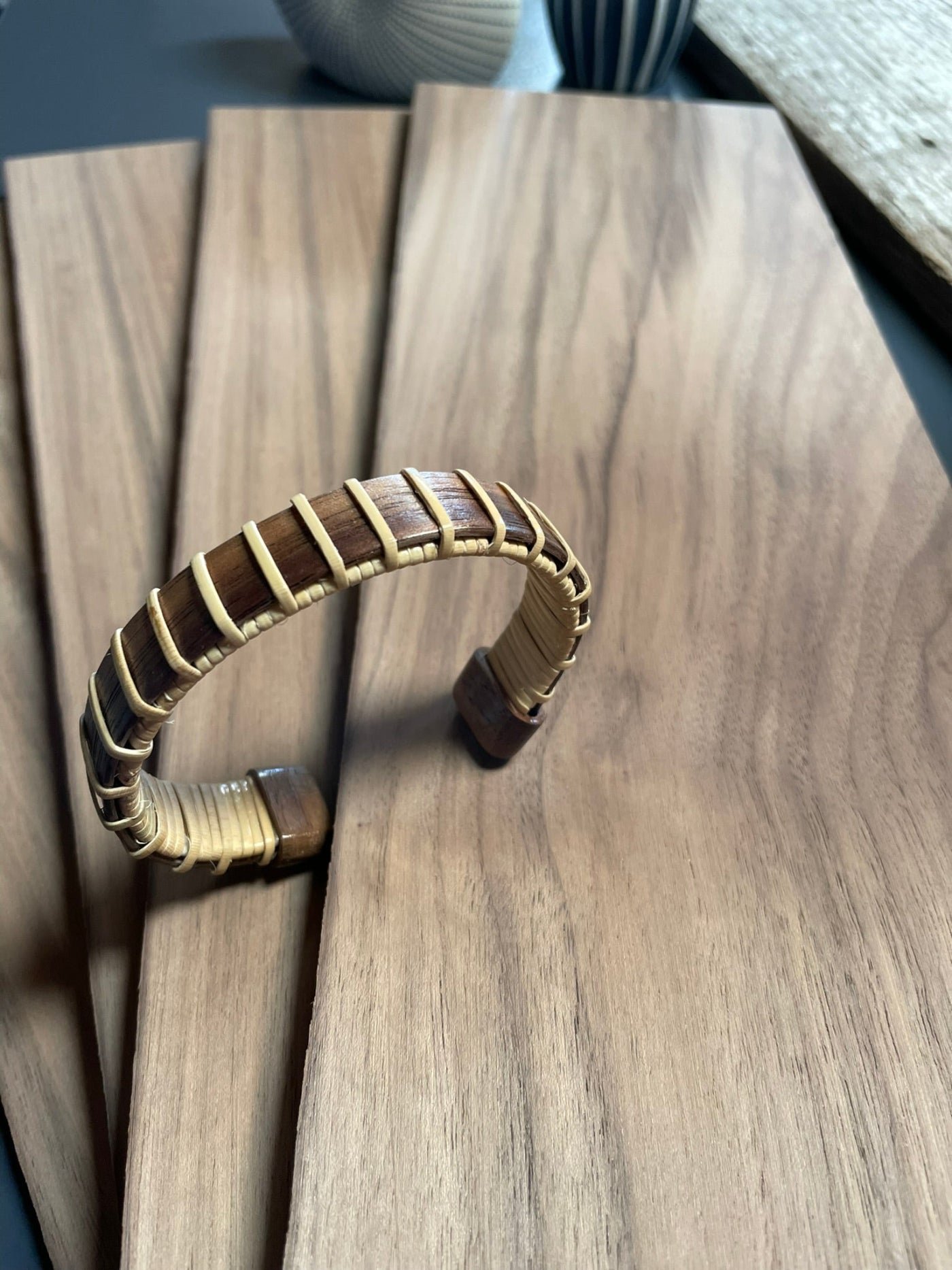 fanned wood on a table with wood cuff bracelet standing up on it