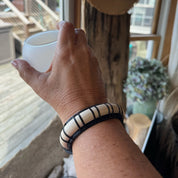 Moonbeam cuff by Stonington Designs worn on a wrist, showing its raised white bamboo stave and black bamboo weaving.