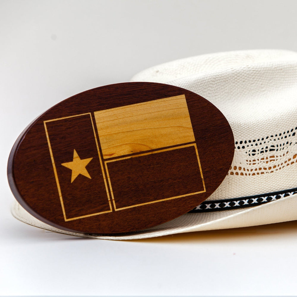 Texas flag inlay pon  wooden hitch cover next to a cowboy hat